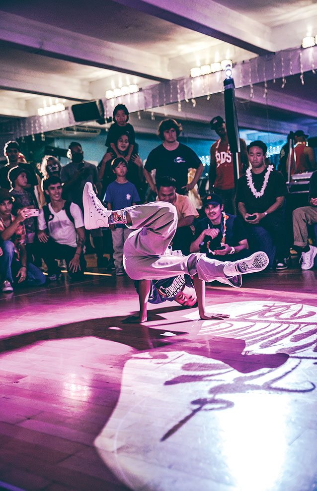 a person doing a handstand on a stage with a crowd watching