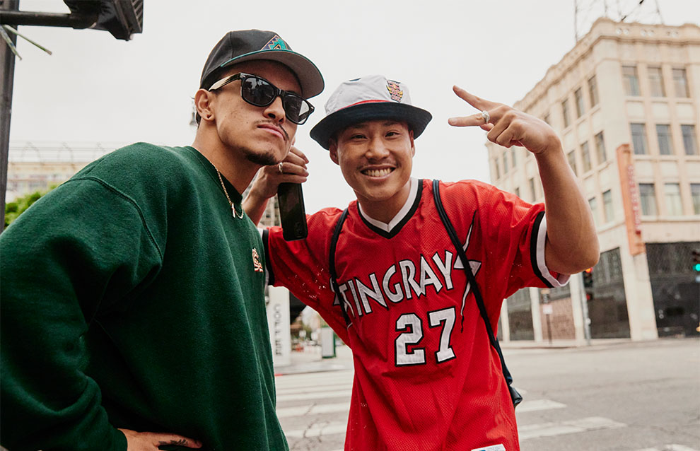 two men standing on a street, posing in streetwear