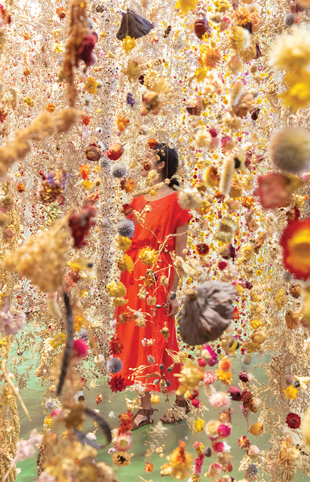 a person in a red dress surrounded by flowers