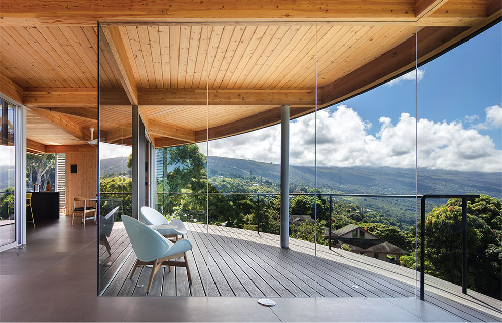 a deck with glass walls and a view of the mountains