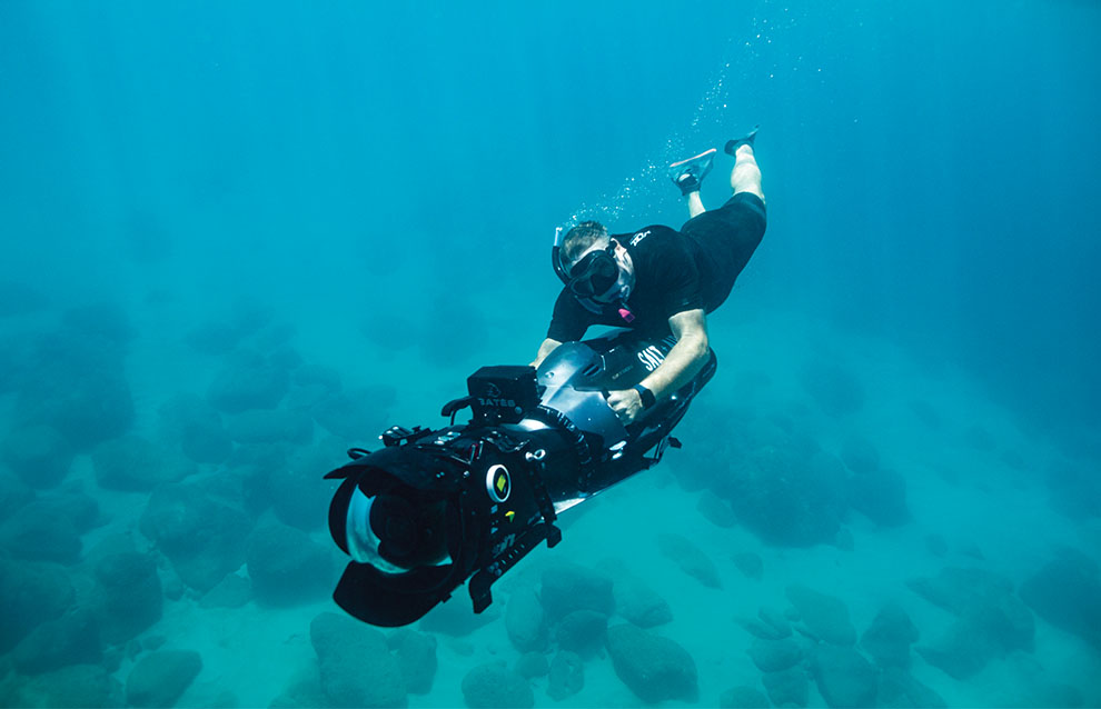 a person swimming underwater with a camera