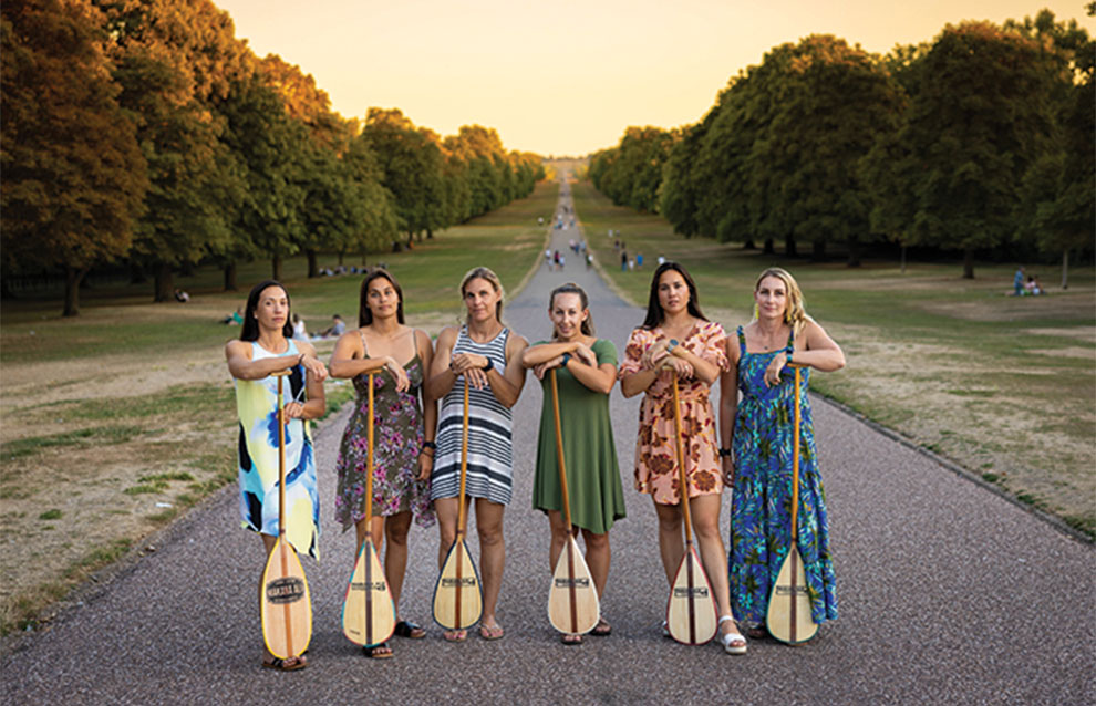 a group of women holding paddles on a road