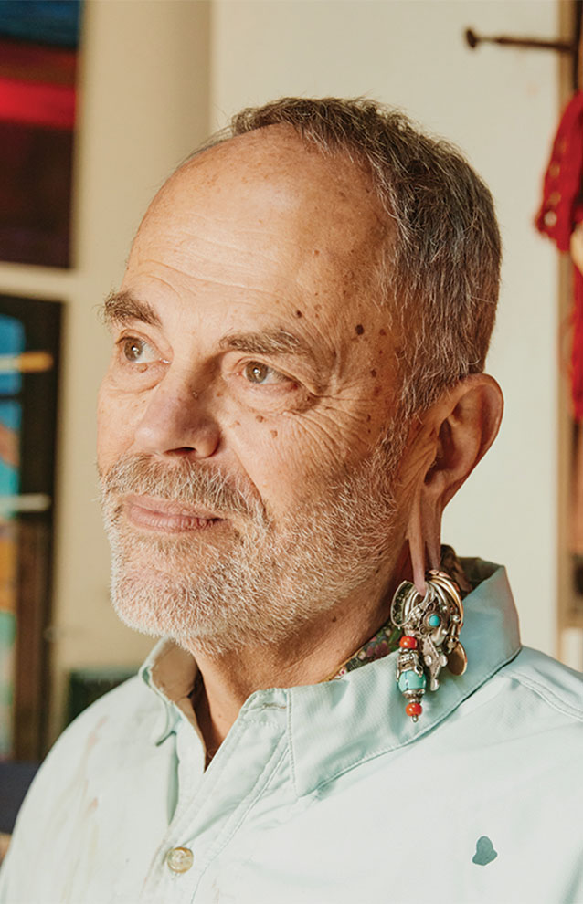 portrait of a man with light blue button down and a decorative ear gauge. 