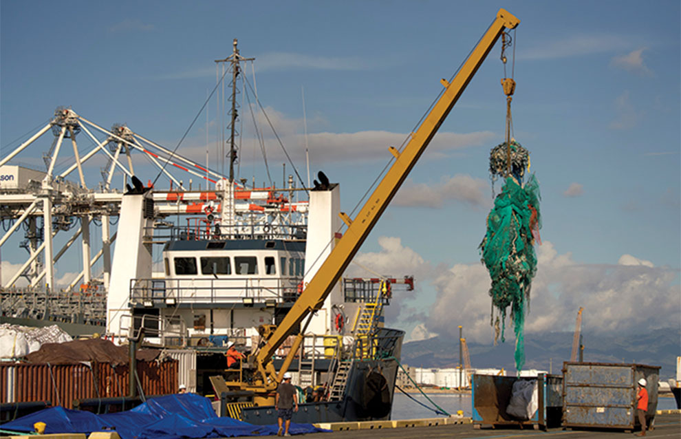 crane pulls full blue net from the ship onto the docks.