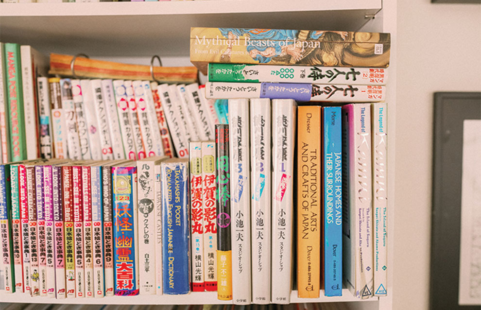 shelf of Japanese anime books stacked crowded together. 