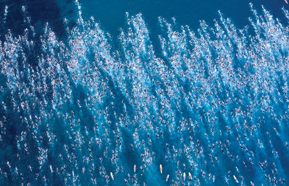 a large group of people swimming in the ocean