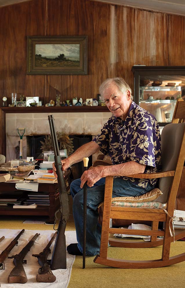an old person sitting in a rocking chair holding a rifle